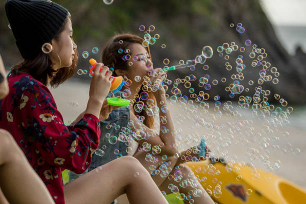 istock Young female having fun and blowing bubbles outdoors 821832642
