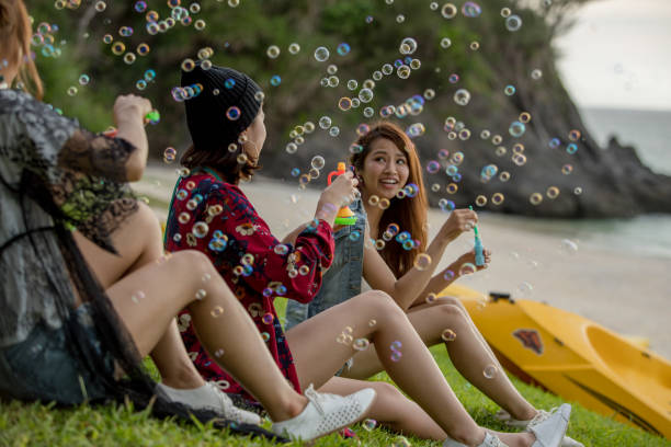istock Young female having fun and blowing bubbles outdoors 821832648