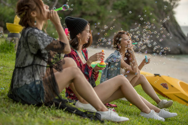 istock Young female having fun and blowing bubbles outdoors 821832652