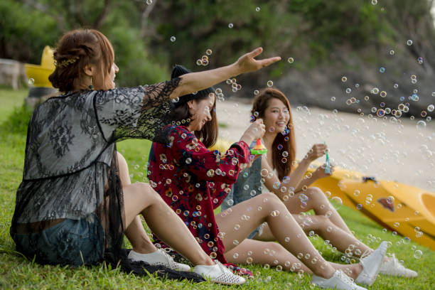 Young female having fun and blowing bubbles outdoors