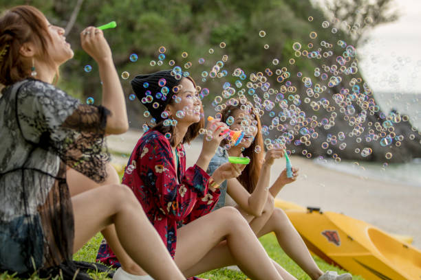 istock Young female having fun and blowing bubbles outdoors 821832680