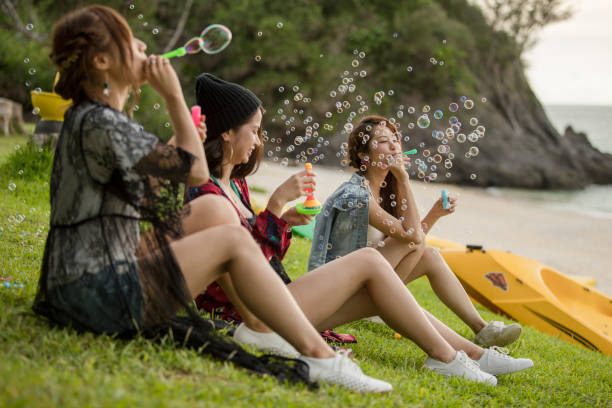 istock Young female having fun and blowing bubbles outdoors 821832682