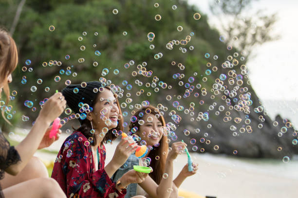 istock Young female having fun and blowing bubbles outdoors 821832684