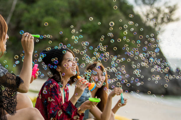 istock Young female having fun and blowing bubbles outdoors 821832692