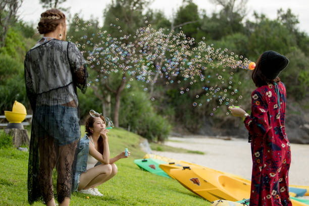Young female having fun and blowing bubbles outdoors