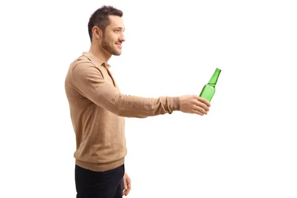 Photo of Young man offering a bottle of beer