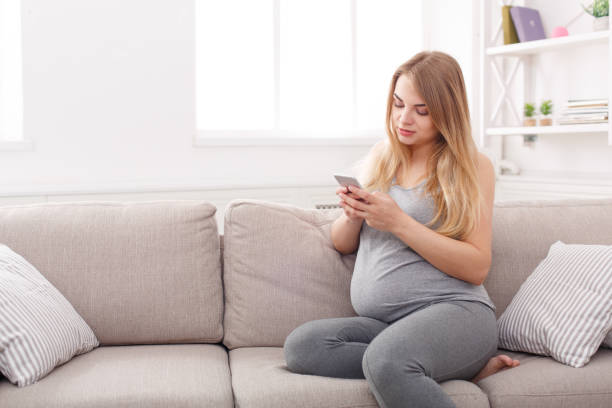 istock Young pregnant woman using smartphone copy space 821840154