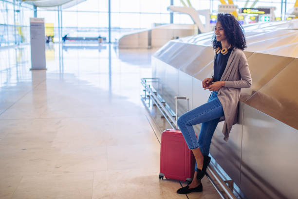 istock black woman waiting her flight using mobile phone at the airport 821840626