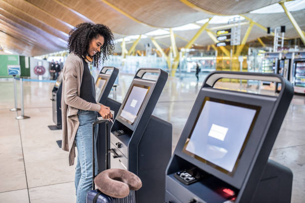 istock happy woman using the check-in machine at the airport getting the boarding pass. 821840636