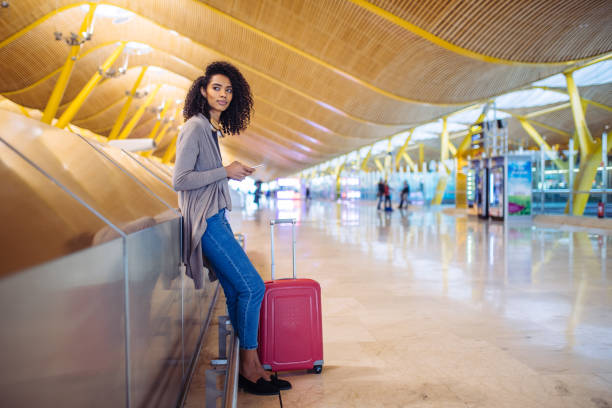 istock black woman waiting her flight using mobile phone at the airport 821840662