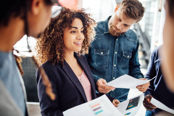 istock Young woman sharing business reports with colleagues. 821848576