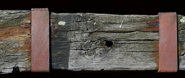 istock Weathered wooden beam with a rusty metallic plate. 821852570
