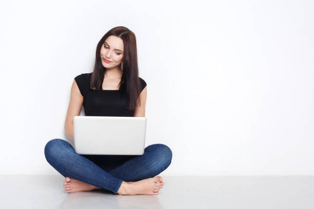 istock Woman using laptop sitting on the studio floor 821856052