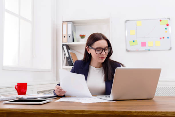 istock Business woman reading document at office desktop 821856844