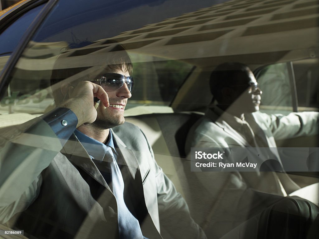 2 men in taxi, one on cell phone  30-34 Years Stock Photo