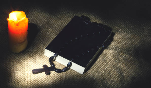 istock cross on book and candle 821861276