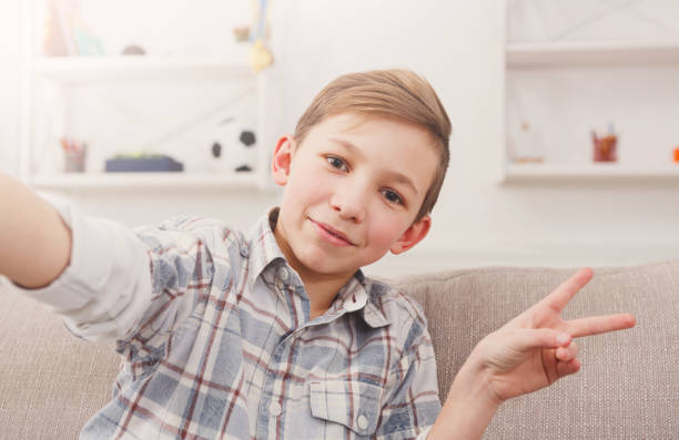 istock Male child taking selfie on phone at home 821872136