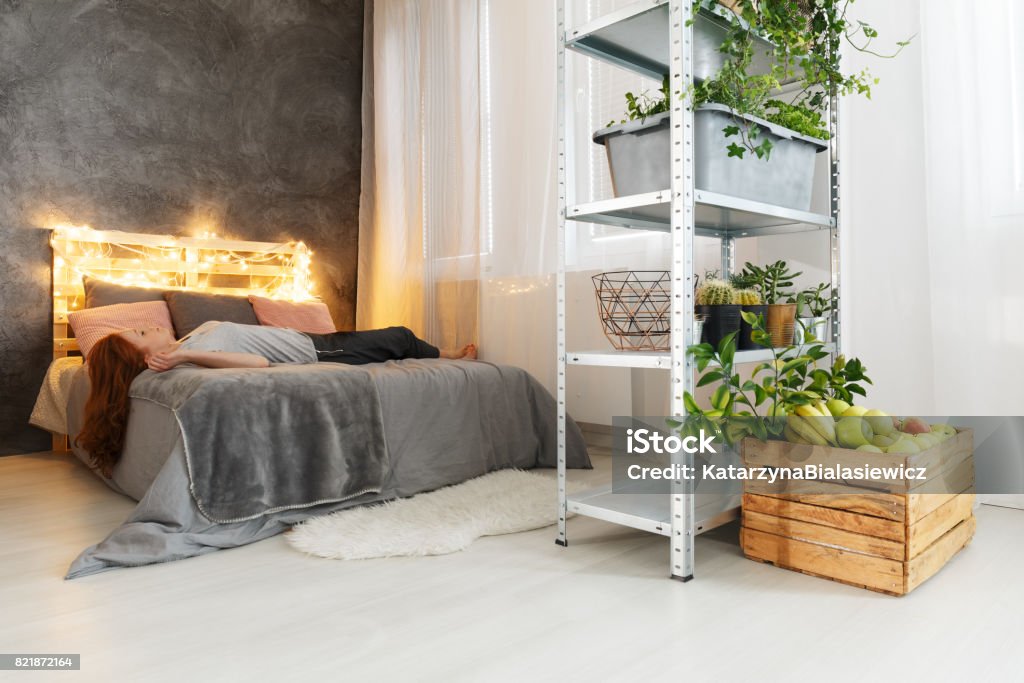 Frau auf Bett liegend in Wohnung - Lizenzfrei Bett Stock-Foto