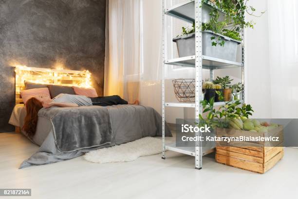 Frau Auf Bett Liegend In Wohnung Stockfoto und mehr Bilder von Bett - Bett, Transportpalette, Holz