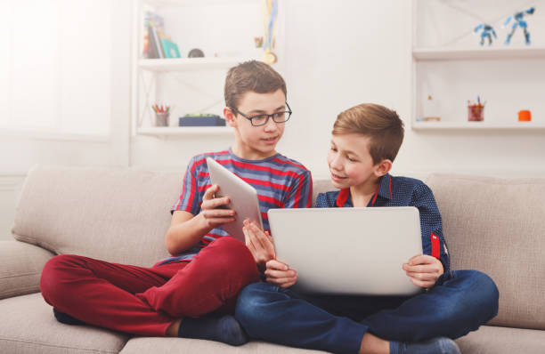istock Two teenage boys using tablet on couch at home 821872262