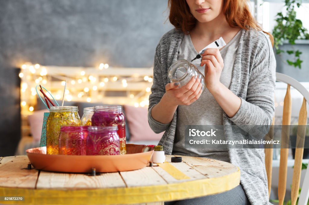 Woman painting jar at home Young beautiful woman painting decorative jar at stylish home Jar Stock Photo