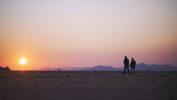 istock Couple walking at sunrise in desert 821872380