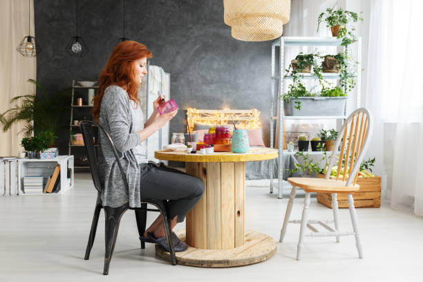 Woman making craft in apartment Young attractive woman making craft in stylish contemporary apartment eclectus parrot stock pictures, royalty-free photos & images