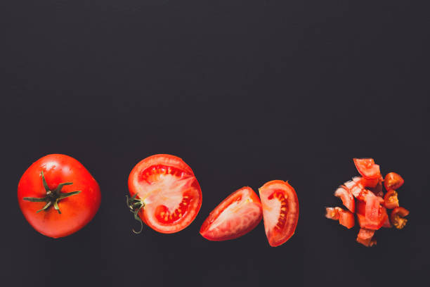 istock Stages of cutting tomato on black background 821876776