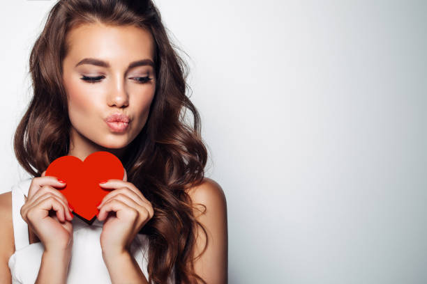 красивая женщина, держащая искусственное сердце - love valentines day heart shape kissing стоковые фото и изображения