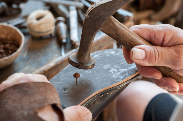 istock The shoemaker repairs a shoe at his work bench 821877810
