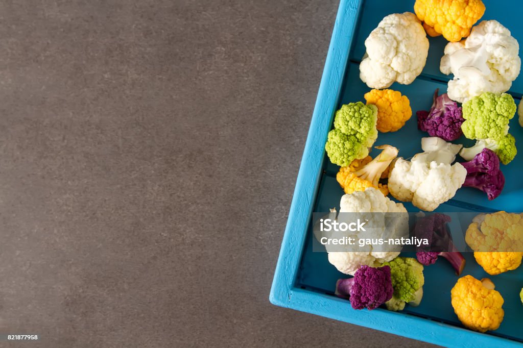 A rainbow of food. Purple cauliflower, orange cauliflower and broccoli, from the local market in London. Food for a vegan and a vegetarian. Dark background. Top view A rainbow of food. Purple cauliflower, orange cauliflower and broccoli, from the local market in London. Food for a vegan and a vegetarian. Dark background Brassica Stock Photo