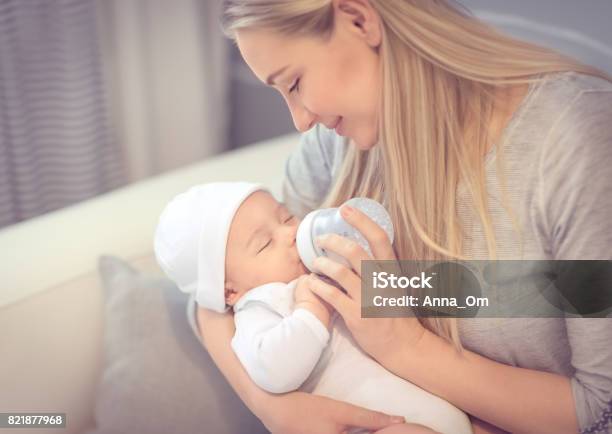 Photo libre de droit de Jeune Mère Nourrit Son Bébé Précieux Petit banque d'images et plus d'images libres de droit de Bouteille - Bouteille, Bébé, Mère