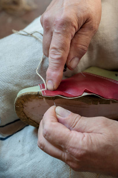 istock The shoemaker repairs a shoe at his work bench 821880338