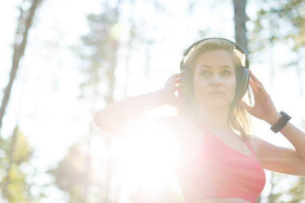 jovem mulher ouvir música usando fones de ouvido. aptidão, conceito de treino - distance running audio - fotografias e filmes do acervo