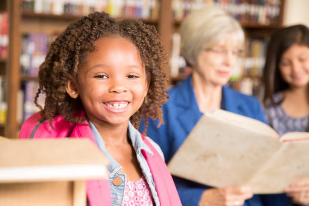 istock African descent little girl in school library. 821894928