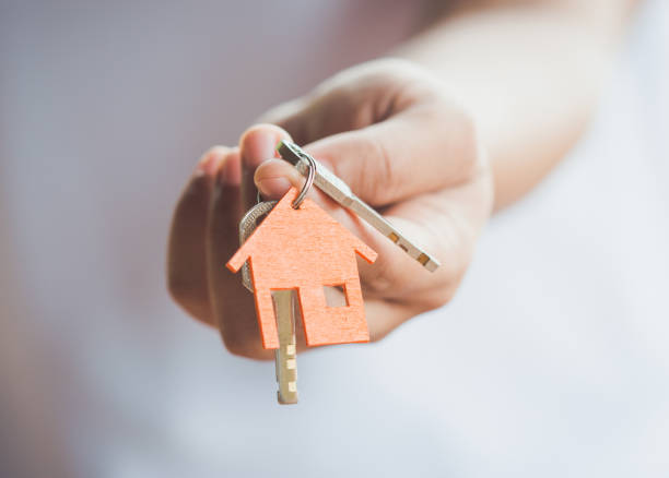 House key in hand Female hand holding keys with house key,real estate agent. property security stock pictures, royalty-free photos & images