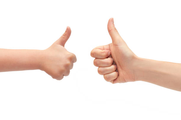 hand of young girl and kids hand gesture, shows thumbs up. Isolated on white background stock photo