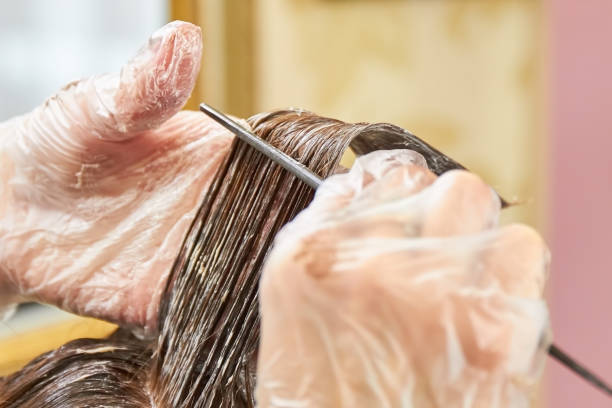istock Hands of beautician dyeing hair. 821902792