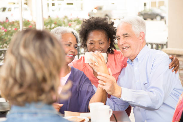 istock Multi-ethnic group of senior adult friends using technology at cafe. 821905140