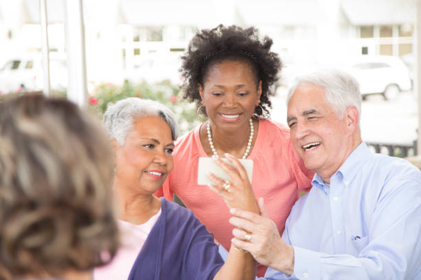 istock Multi-ethnic group of senior adult friends using technology at cafe. 821910254