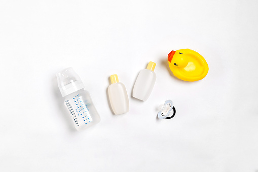 Baby accessories for bath with duck on white background. Top view. Copy space. Still life. Flat lay