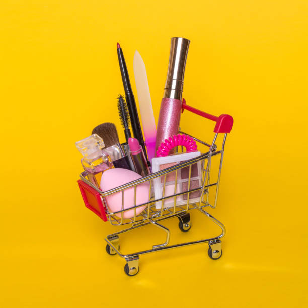 istock Creative concept with shopping trolley with makeup on a yellow background. 821919620