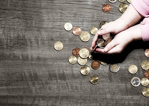 Child's hands holding coins young child holding euro currency coins, coins spilling onto table netherlands currency stock pictures, royalty-free photos & images