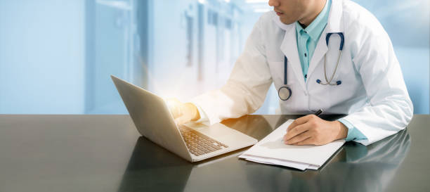 istock Doctor working on desk with laptop 821922034