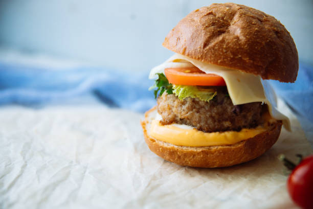 istock Tasty burger with beef with spinach and blue cheese served on a small board on a wooden background. 821922744