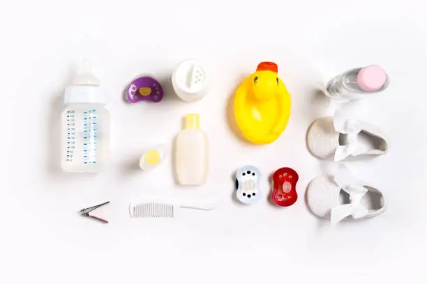 Hairbrush and cosmetics for newborns on a white background. Top view. Copy space. Still life. Flat lay