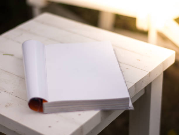 istock Close up the white book on the table in garden with sun light 821937676