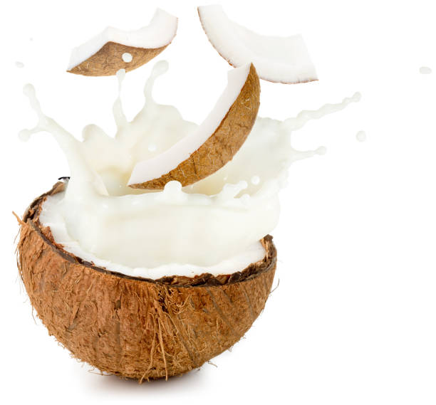 coconut milk and pieces spilling out half nut - fruit freshness tree foods and drinks imagens e fotografias de stock