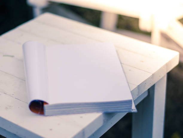 istock Close up the white book on the table in garden with sun light 821938418