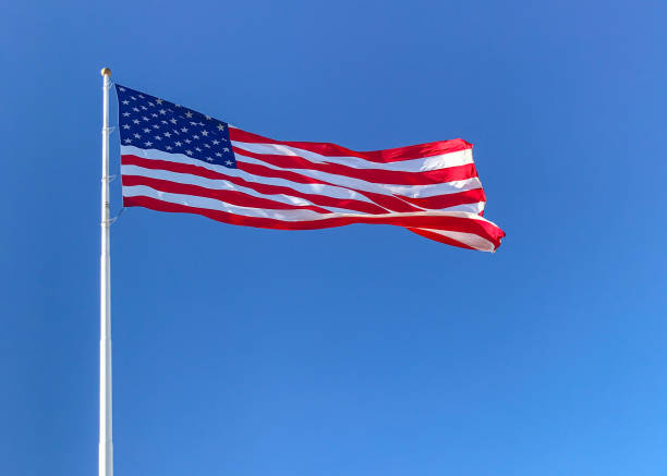 istock American flag waving in blue sky. 821938598